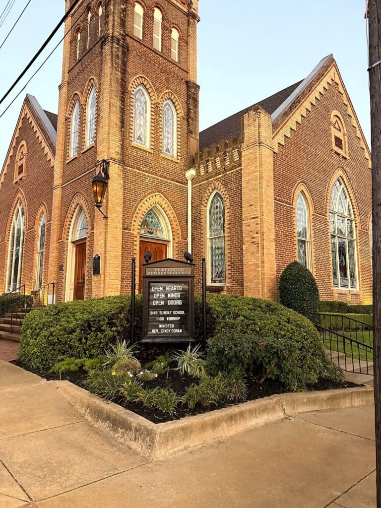 First United Methodist Church in Crockett with clipped hedges and a planted corner bed